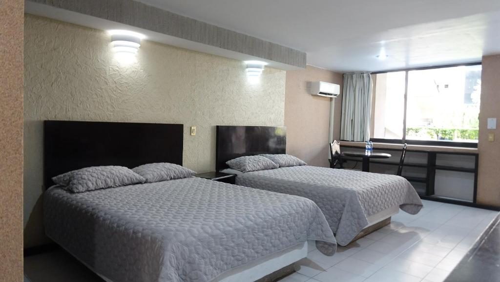 Spacious room with two full beds at Hotel Montecarlo Jojutla
