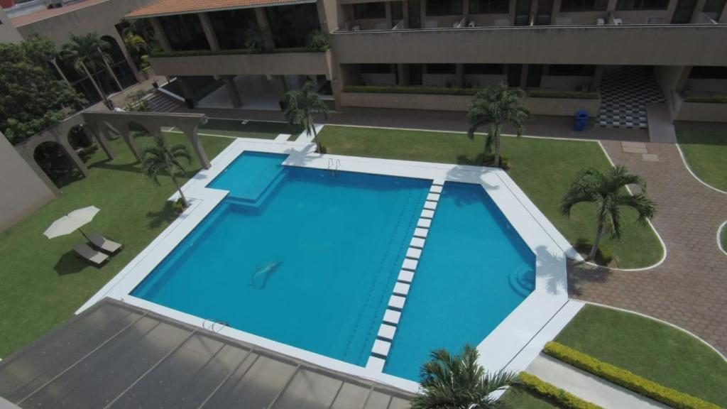 Large outdoor swimming pool surrounded by green areas